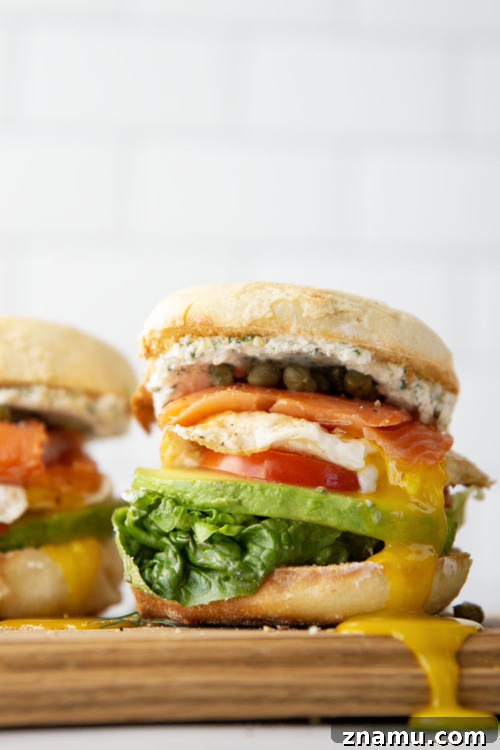 Gourmet Smoked Salmon & Goat Cheese Breakfast Sandwich 5 Various ingredients for a smoked salmon breakfast sandwich laid out on a wooden board.