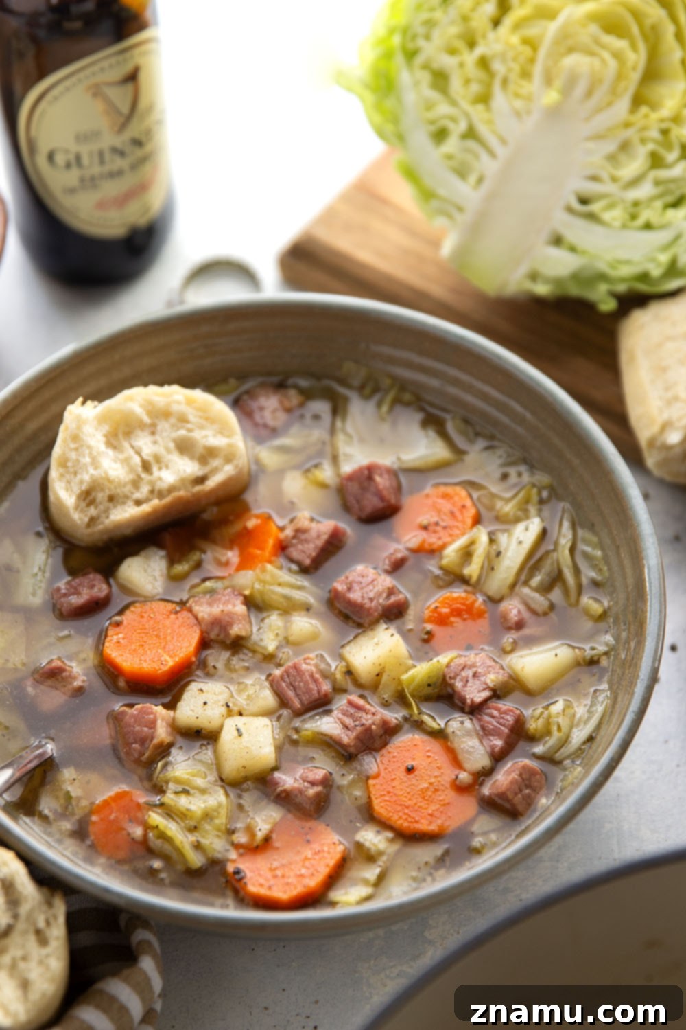 Hearty Corned Beef and Cabbage Stew 2 A steaming bowl of hearty corned beef cabbage soup with chunks of beef, potatoes, carrots, and green cabbage, garnished with fresh parsley.