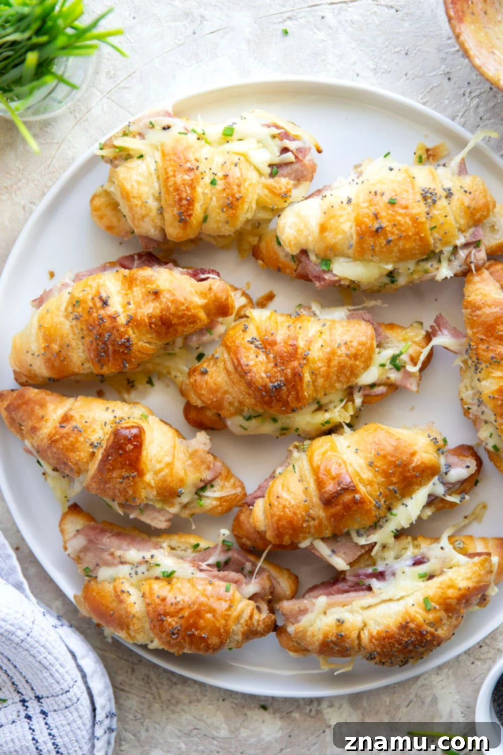Melted Gruyere Ham Croissant Sliders 6 A baked Gruyere Ham and Cheese Croissant Slider lifted from the pan, showing off its golden crust.