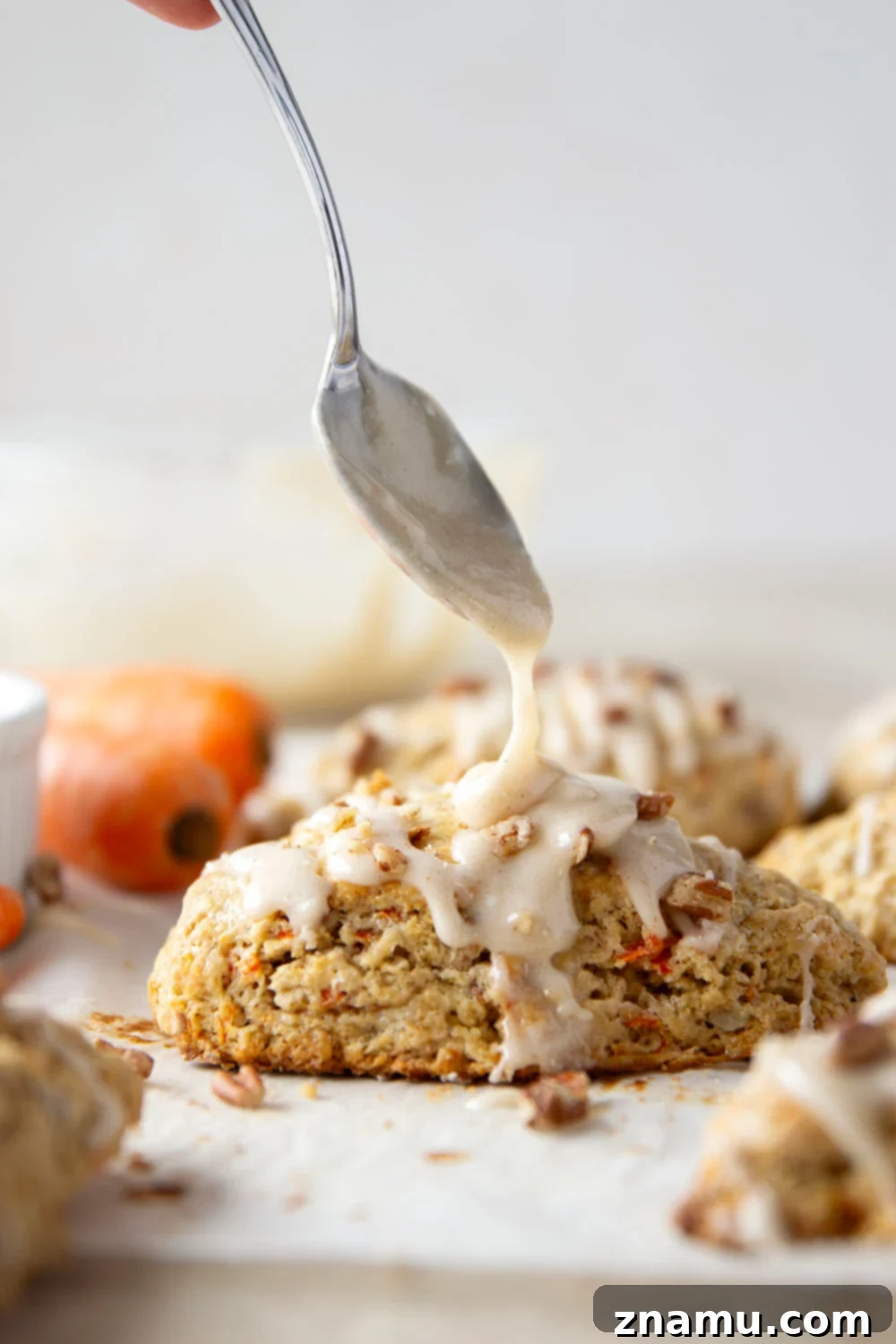 Spiced Carrot Cake Scones 2 Soft and tender carrot cake scones feature lots of toasted pecans, shredded carrots, and a silky cream cheese glaze drizzled on top.