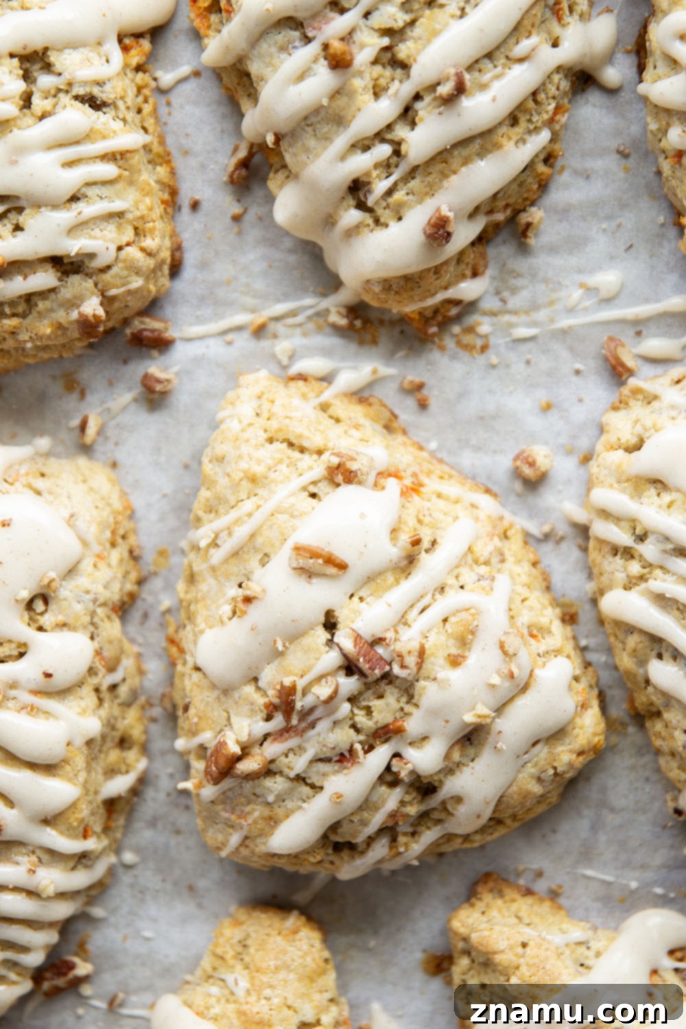 Spiced Carrot Cake Scones 4 Soft and tender carrot cake scones feature lots of toasted pecans, shredded carrots, and a silky cream cheese glaze drizzled on top.