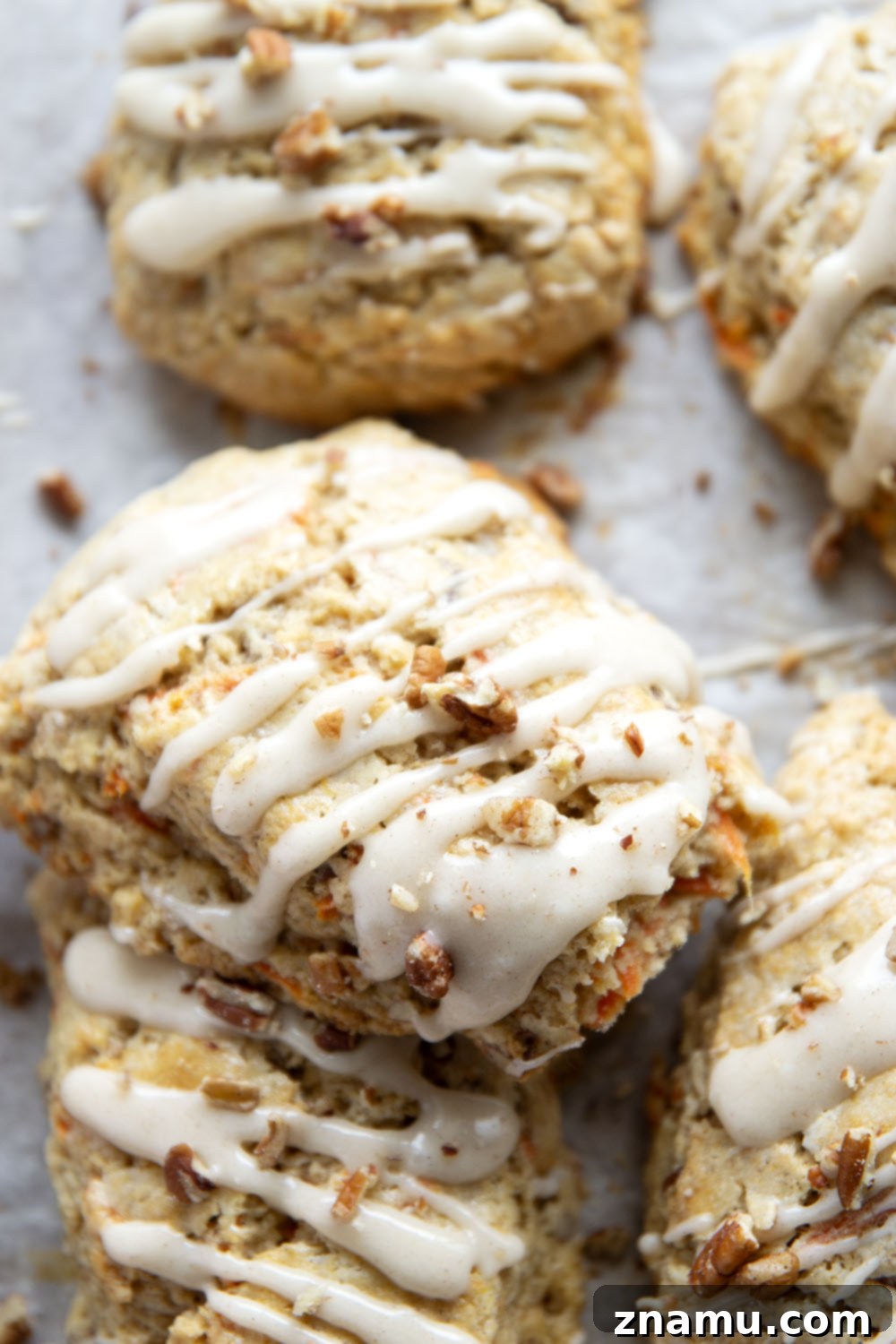 Spiced Carrot Cake Scones 6 Soft and tender carrot cake scones feature lots of toasted pecans, shredded carrots, and a silky cream cheese glaze drizzled on top.