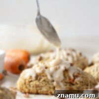 Soft and tender carrot cake scones feature lots of toasted pecans, shredded carrots, and a silky cream cheese glaze drizzled on top.