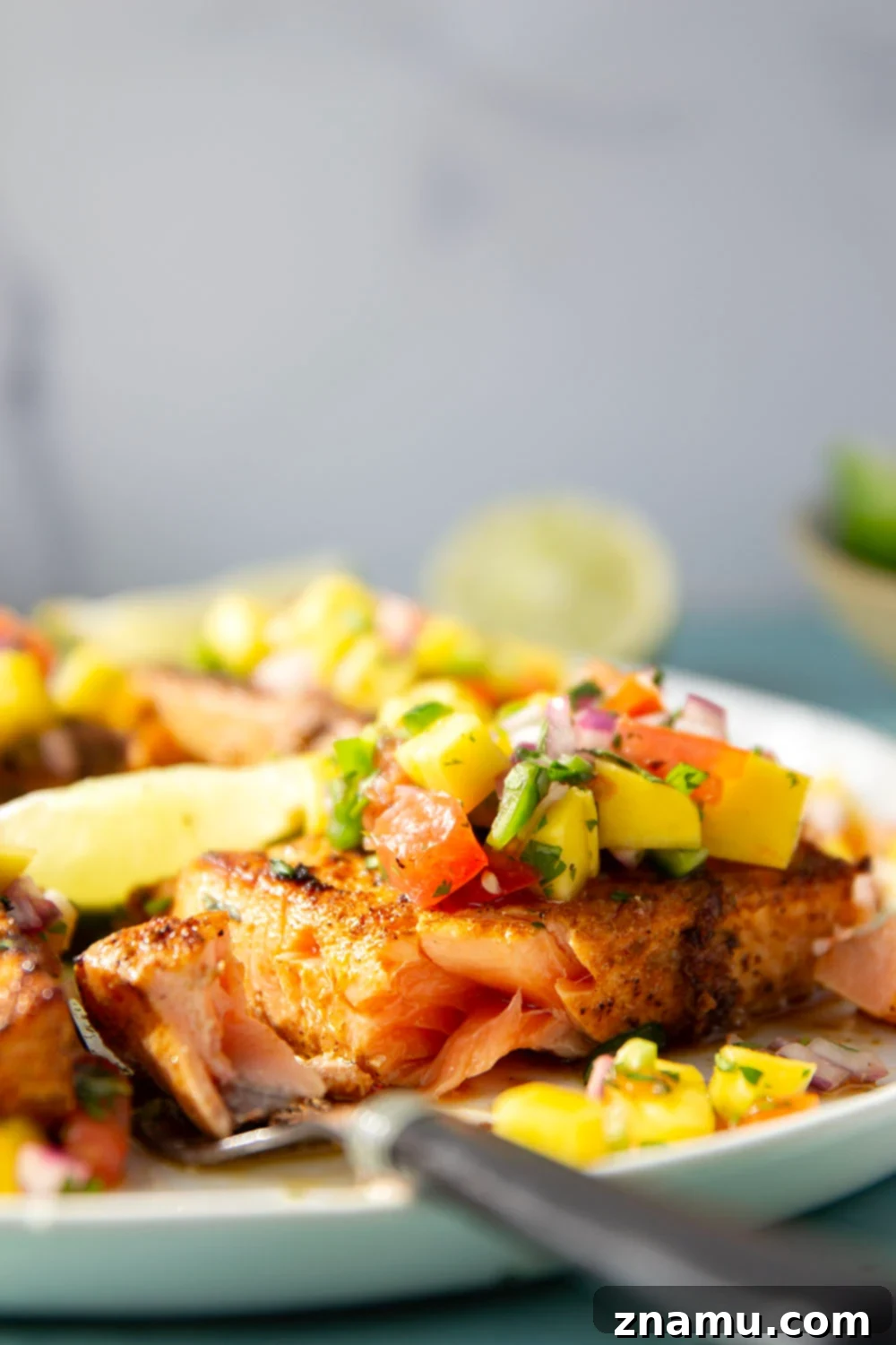 Marinated in a fresh lime and chili sauce, grilled to perfection, and topped with a super fresh mango salsa, this grilled chili lime salmon is an easy dinner that's full of flavor!