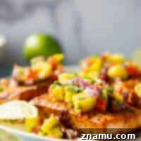 Marinated in a fresh lime and chili sauce, grilled to perfection, and topped with a super fresh mango salsa, this grilled chili lime salmon is an easy dinner that's full of flavor!