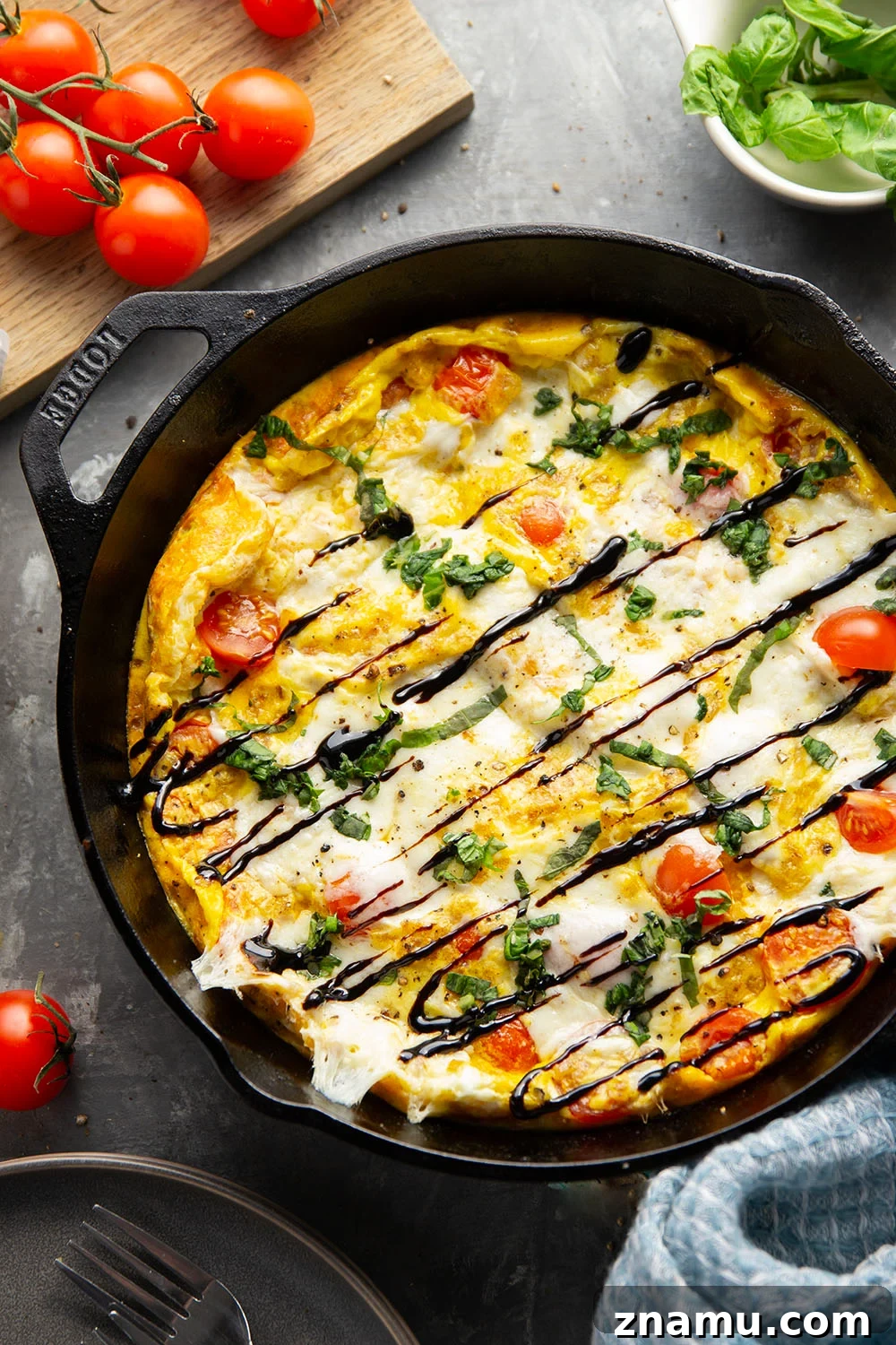 Caprese Frittata Recipe with Fresh Tomatoes, Basil & Mozzarella 2 Caprese frittata with fluffy eggs, cherry tomatoes, fresh mozzarella, basil, and balsamic glaze.