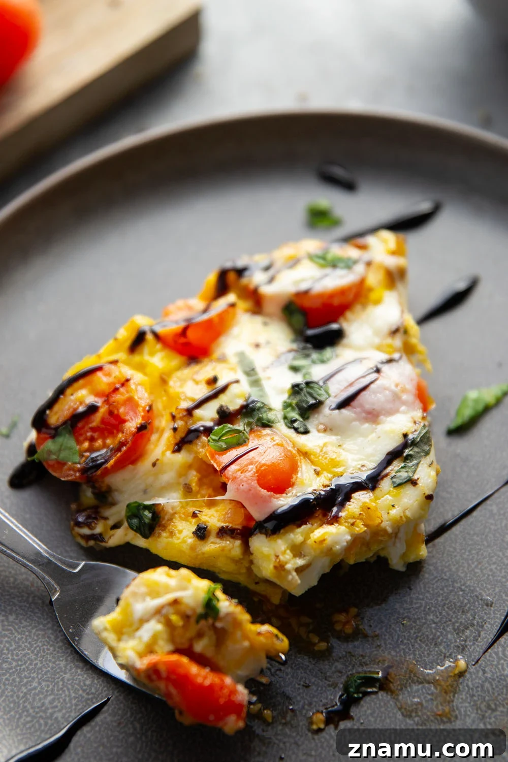 Caprese Frittata Recipe with Fresh Tomatoes, Basil & Mozzarella 5 Slices of caprese frittata on a plate with basil garnish.