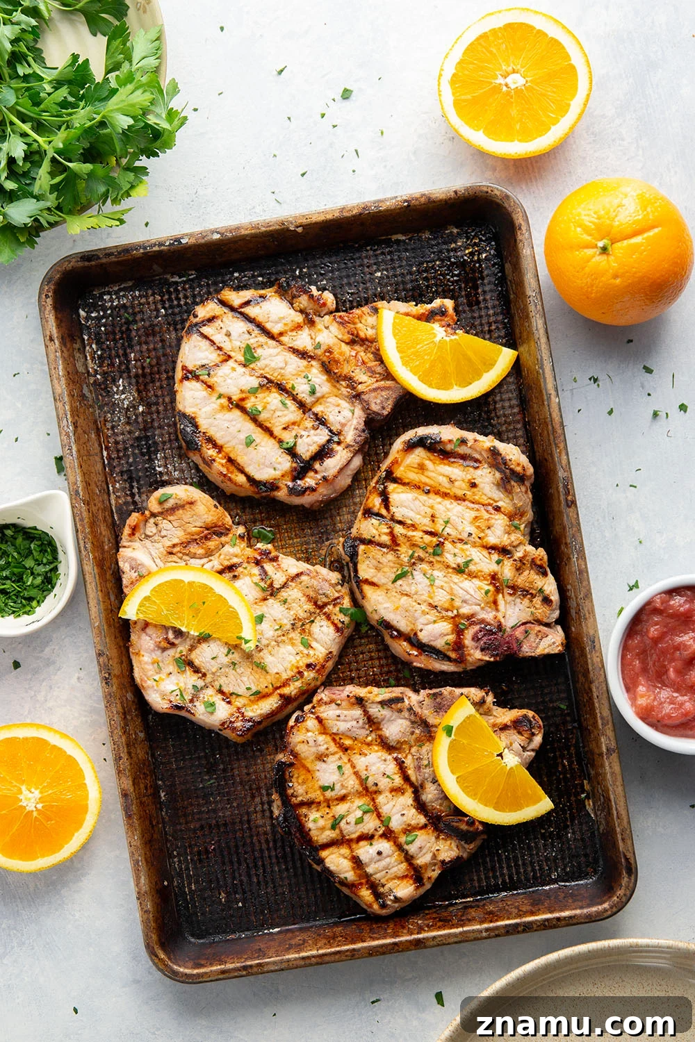 These grilled orange pork chops feature pork chops marinated in a fresh orange marinade, grilled until perfectly juicy, and served with a sweet and tangy rhubarb compote.