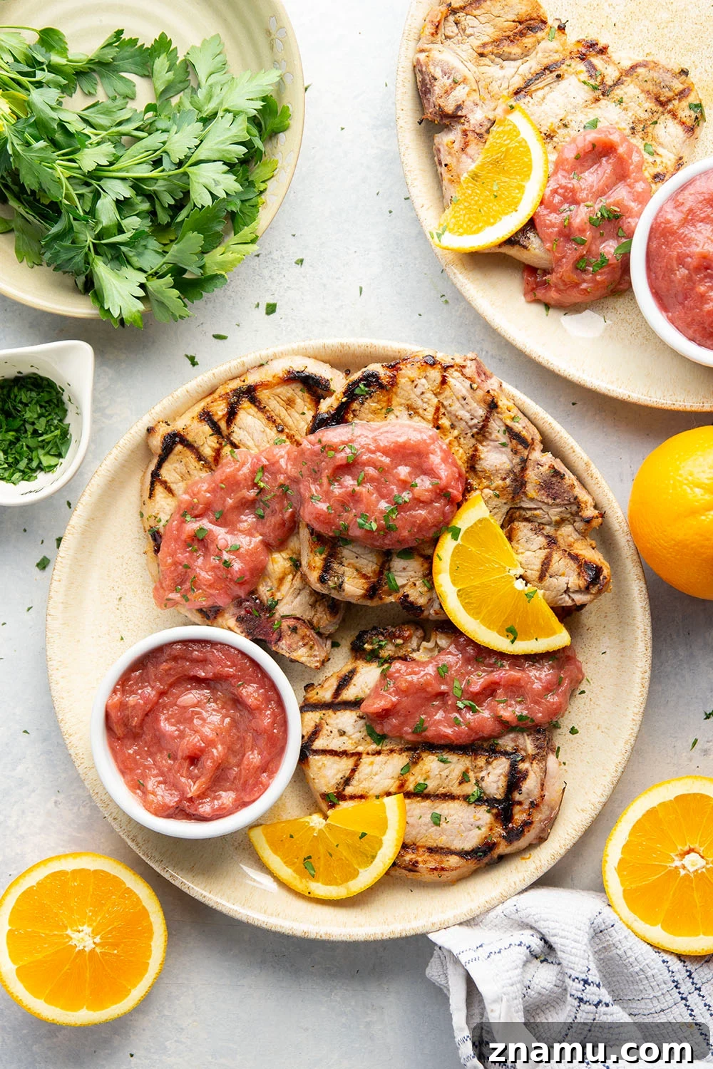 These grilled orange pork chops feature pork chops marinated in a fresh orange marinade, grilled until perfectly juicy, and served with a sweet and tangy rhubarb compote.