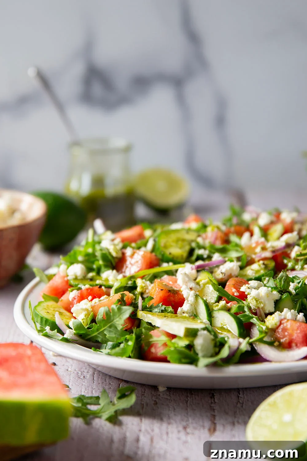 Sweet watermelon, tangy feta, and crisp cucumbers are the best salad combo in this watermelon feta cucumber salad that gets dressed in a fresh basil lime dressing and goes well with any summer meal.