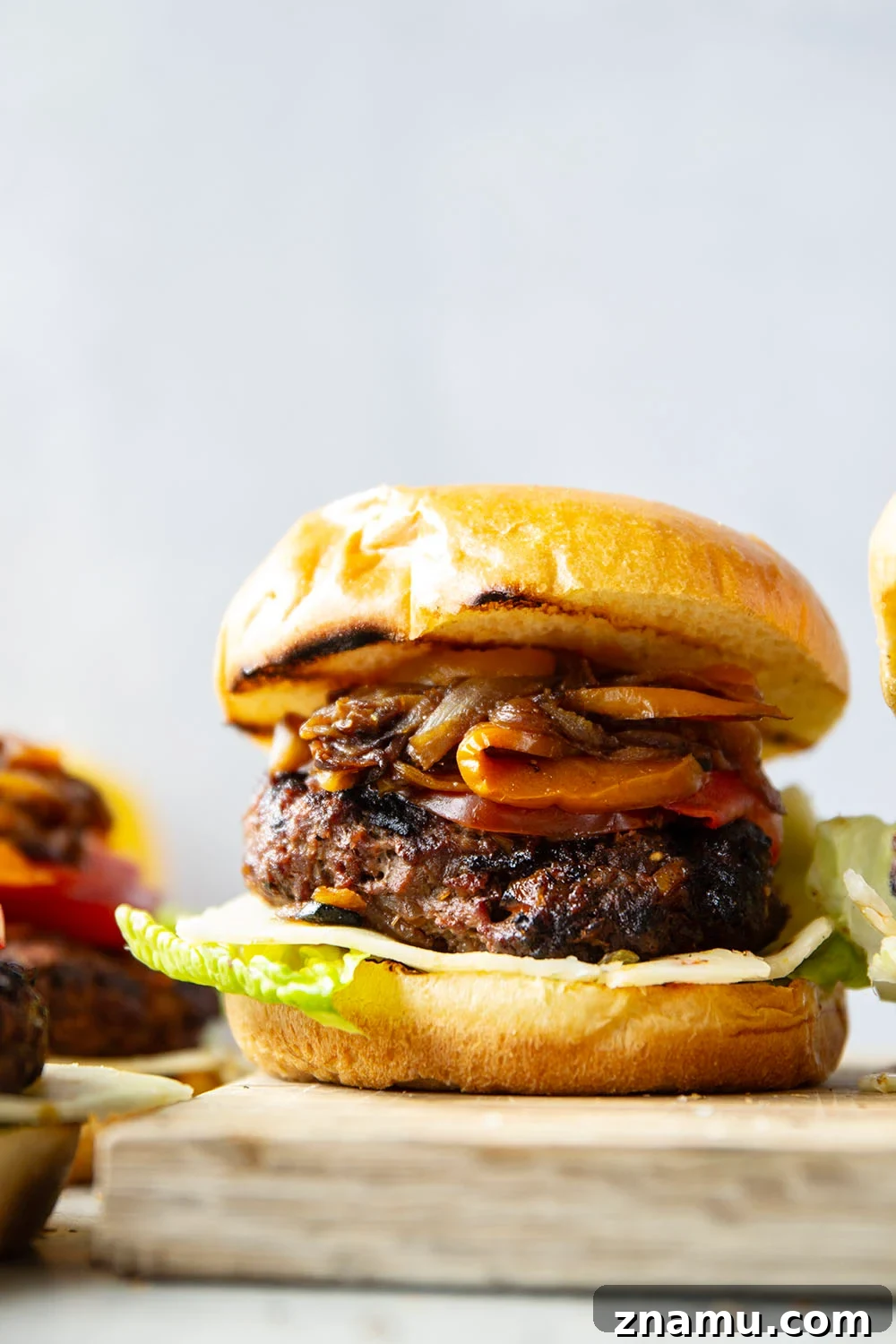 Juicy Burger with Caramelized Onions and Sweet Peppers 2 This juicy caramelized onion burger features caramelized onions and sweet peppers packed both inside the burger for extra flavor and more piled on top with a slice of pepperjack cheese and crisp lettuce.