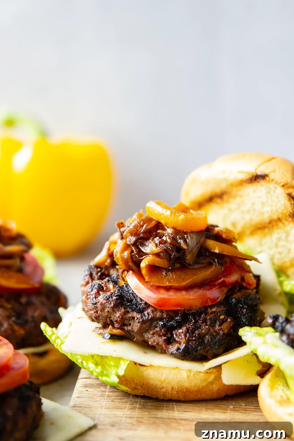 Juicy Burger with Caramelized Onions and Sweet Peppers 5 This juicy caramelized onion burger features caramelized onions and sweet peppers packed both inside the burger for extra flavor and more piled on top with a slice of pepperjack cheese and crisp lettuce.