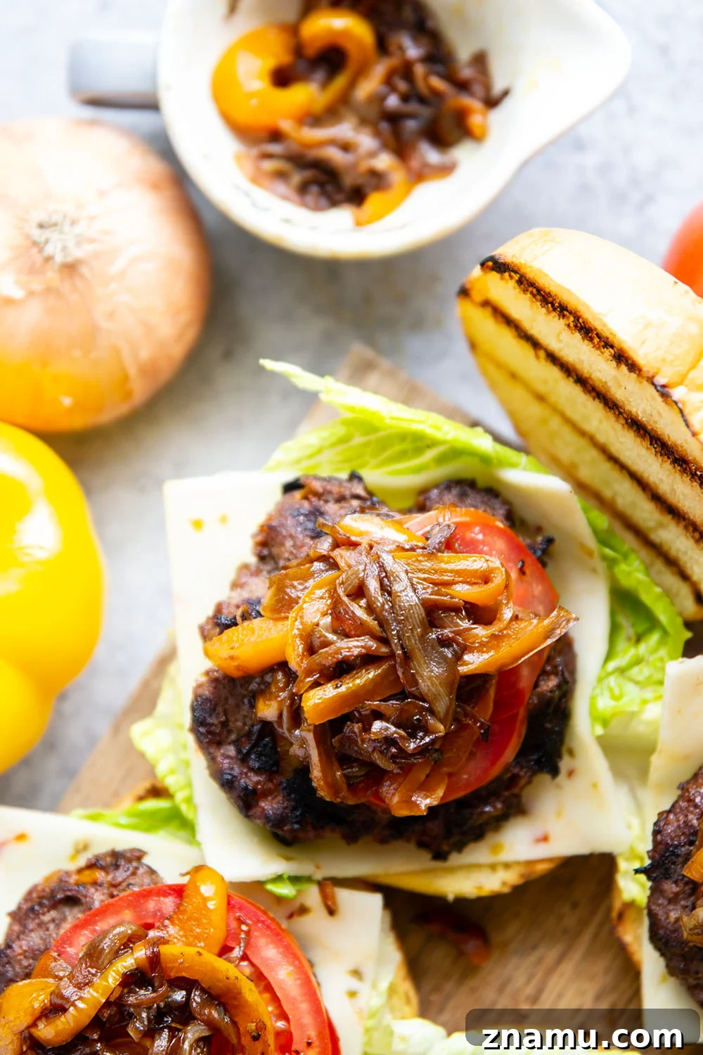 Juicy Burger with Caramelized Onions and Sweet Peppers 6 This juicy caramelized onion burger features caramelized onions and sweet peppers packed both inside the burger for extra flavor and more piled on top with a slice of pepperjack cheese and crisp lettuce.