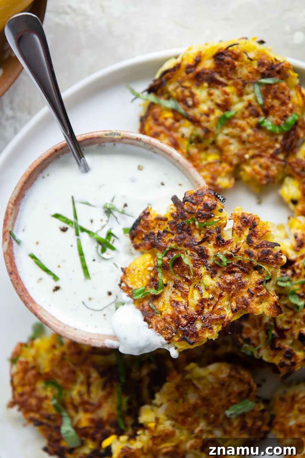 Crispy Yellow Squash Fritters with Basil Sour Cream 2 These yellow squash fritters feature perfectly crispy exteriors with a moist, flavorful texture inside. Serve them hot and crispy from the skillet with an herby fresh basil sour cream.